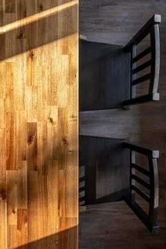 Wooden dining table and black chairs. Vertical top view with warm sunlight .. Stock Photos