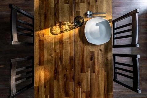 Wooden dining table with empty place setting. Sunlit tabletop with copy space Stock Photos