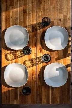 Wooden dining table set for four. Vertical top view with plates, glasses an.. Stock Photos