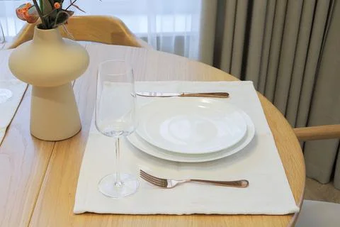 Wooden dining table setup with plates Stock Photos