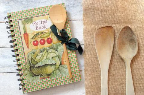 Wooden dipper kitchenware and a recipe book on a sackcloth Stock Photos