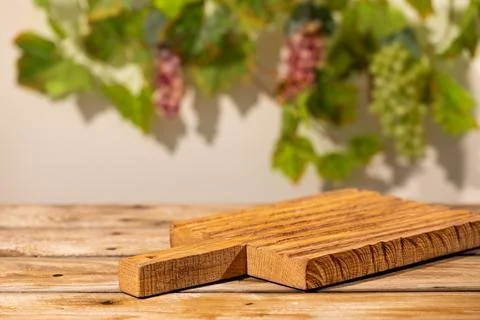 Wooden display stand on rustic table with blurred grape leaves as autumn pr.. Stock Photos