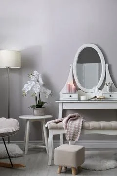 Wooden dressing table with decorative elements and makeup products in room. I Stock Photos