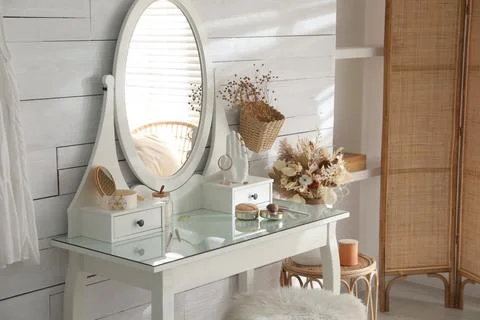 Wooden dressing table with decorative elements and makeup products in room. I Stock Photos