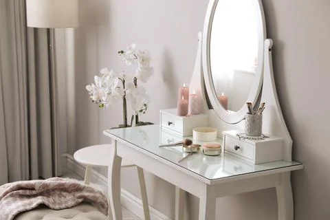 Wooden dressing table with decorative elements and makeup products in room. I Stock Photos
