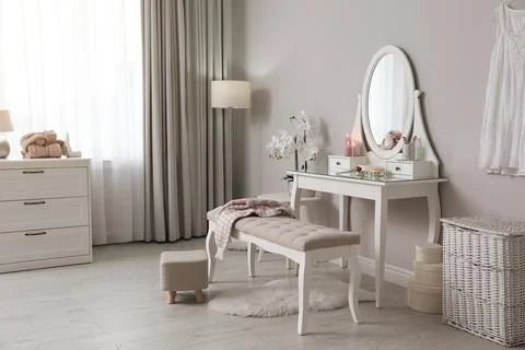 Wooden dressing table with decorative elements and makeup products in room. I Stock Photos