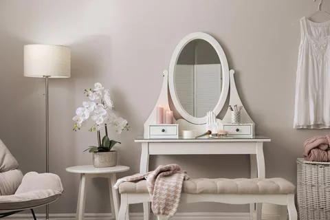 Wooden dressing table with decorative elements and makeup products in room. I Stock Photos