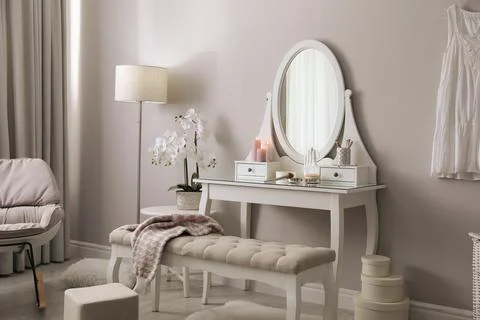 Wooden dressing table with decorative elements and makeup products in room. I Stock Photos