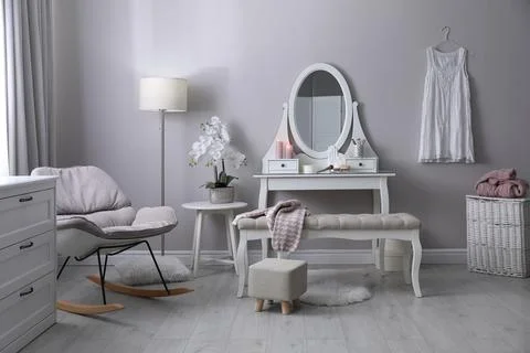 Wooden dressing table with decorative elements and makeup products in room. I Stock Photos