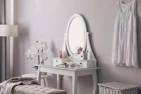 Wooden dressing table with decorative elements and makeup products in room. I Stock Photos