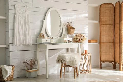 Wooden dressing table with decorative elements and makeup products in room. I Stock Photos