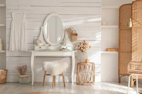 Wooden dressing table with decorative elements and makeup products in room. I Stock Photos