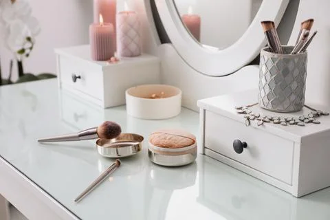 Wooden dressing table with decorative elements and makeup products in room Stock Photos