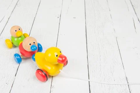 Wooden duck pull toy with a string on a white wooden background Foto stock