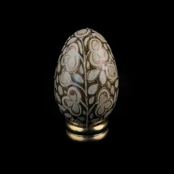 Wooden Easter egg with floral patterns on isolated black background 库存照片