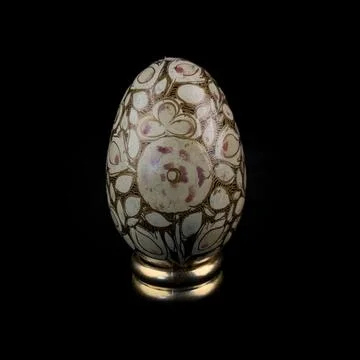 Wooden Easter egg with floral patterns on isolated black background 库存照片