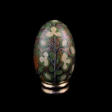 Wooden Easter egg with floral patterns on isolated black background 库存照片