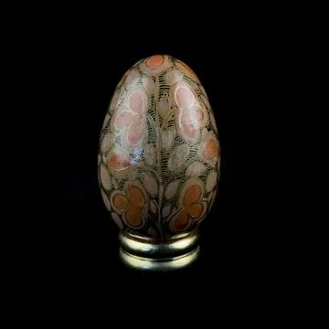 Wooden Easter egg with floral patterns on isolated black background 库存照片
