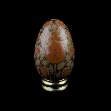 Wooden Easter egg with floral patterns on isolated black background 库存照片