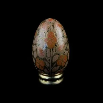 Wooden Easter egg with floral patterns on isolated black background 库存照片