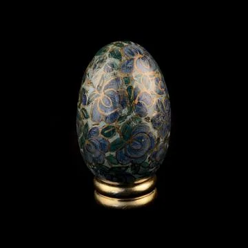 Wooden Easter egg with floral patterns on isolated black background 库存照片