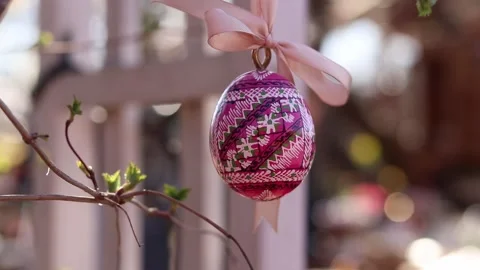 Wooden Easter egg painted with bright patterns is hung on a ribbon 스톡 동영상 332154203