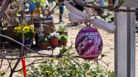 Wooden Easter egg painted with bright patterns is hung on a ribbon Stock Footage 332154209