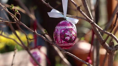 Wooden Easter egg painted with bright patterns is hung on a ribbon Stock Footage 332154216