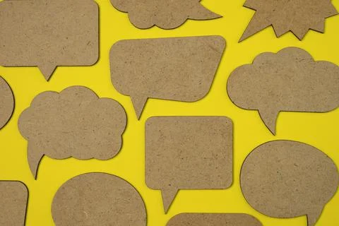Wooden empty speech bubbles concept on yellow paper background. Foto stock