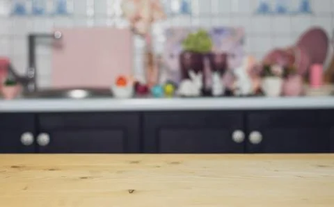 Wooden empty table on the background of the kitchen with Easter eggs, hares Stock Photos