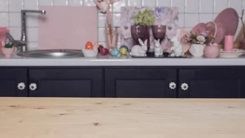 Wooden empty table on the background of the kitchen with Easter eggs, hares Foto stock