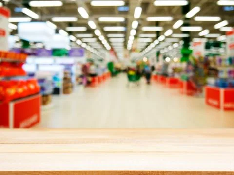 Wooden empty table in front of blurred supermarket Stock-Fotos
