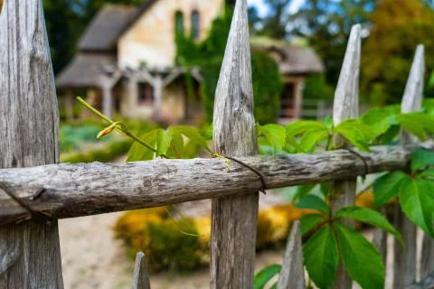 A wooden fence in front of a traditional house Stock Photos