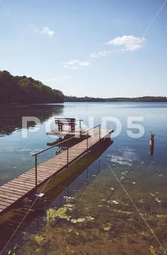 Wooden fishing and recreation platform at Lipie Lake on a sunny