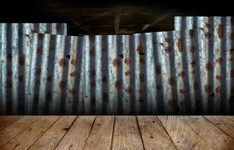Wooden floor with the backdrop of rusty corrugated iron sheets Stock Photos