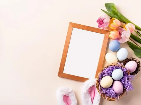 Wooden frame with easter decorations flat lay on beige background Stockfoto's