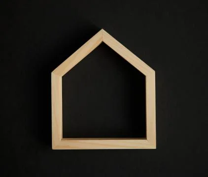 Wooden frame in the shape of a house on black background Stock Photos