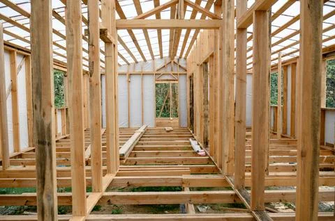 Wooden framework of a house under construction with open interior view Stock Photos
