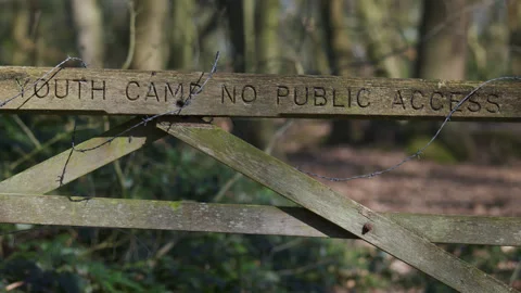 Wooden gate with barbed wire in dappled shade of trees  - close up 1. 4K tripod Stock Footage 177262353