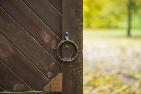 Wooden gate with handle in the shape of a ring of metal Stock Photos