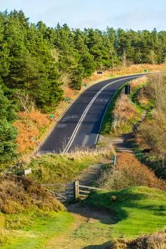 Wooden gate at a hiking path in front of a countryside road in Yorkshire Engl Foto stock