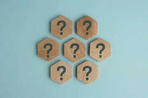 Wooden hexagonal pieces with question marks arranged in a geometric pattern.. Photos