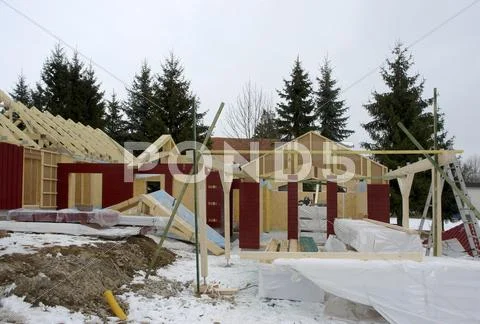 Wooden house construction at winter time Stock Photos