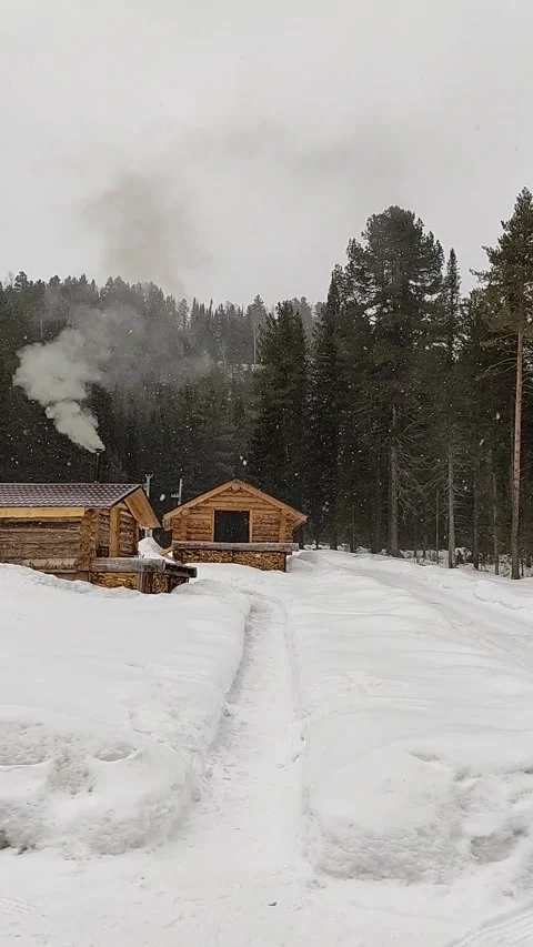 A wooden house in the mountains during a snowfall. Stock Footage 268009819