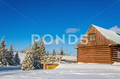 Wooden house in winter landscape, sunny day Stock Photos