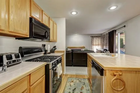 Wooden kitchen interior with large kitchen island and black appliances. North Stock Photos