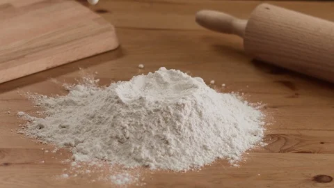 On the wooden kitchen table shef pouring milk into flour . 4K slow motion video Stock Footage 111640862