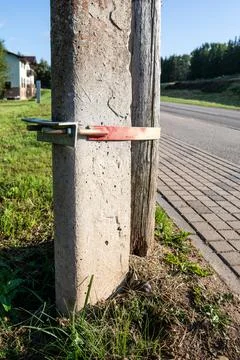 A wooden log attached to a concrete post with a turnbuckle. Fixing the electric Stock Photos