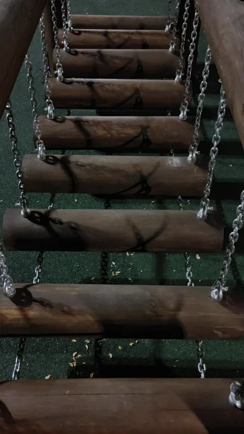 Wooden log suspension bridge on chains at playground at night. Stock Footage 343672449