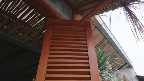 Wooden louvered shutter panel under a rustic bamboo roof ceiling. Video stock 343377087